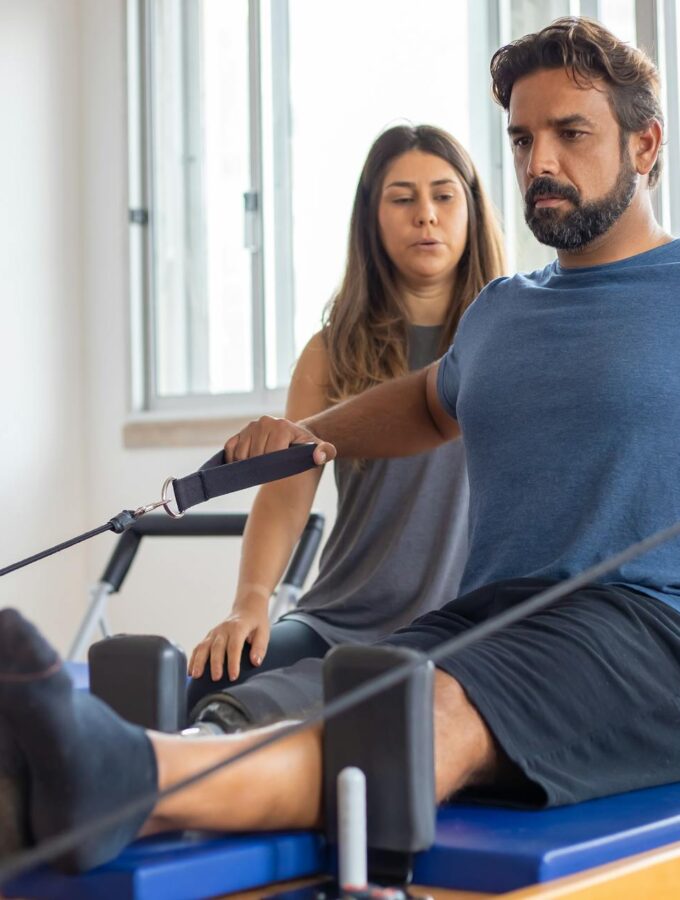 Man exercising with a physical therapist- Image Courtesy of Pexels